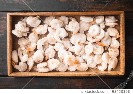 Boiled and frozen shrimps, in wooden box, on old dark wooden table , top view flat lay Boiled and frozen shrimps, in wooden box, on old dark wooden table , top view flat lay 98450398