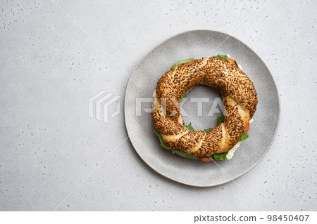 Traditional Turkish bagel simit, breakfast, on gray concrete table background, top view flat lay, with copy space for text Traditional Turkish bagel simit, breakfast, on gray concrete table background, top view flat lay, with copy space for text 98450407