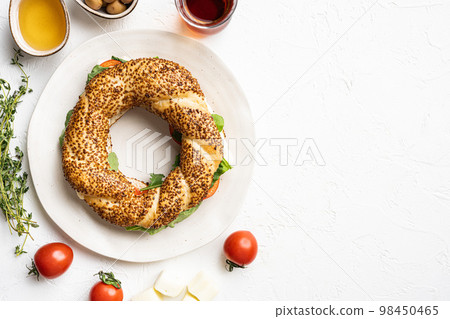 Fast Turkish breakfast Simit with cheese and greenswith glass of turkish black tea with glass of turkish black tea, on white stone table background, top view flat lay, with copy space for text Fast Turkish breakfast Simit with cheese and greenswith glass of turkish black tea with glass of turkish black tea, on white stone table background, top view flat lay, with copy space for text 98450465