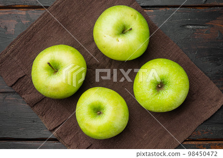 Green apple, on old dark rustic table background, top view flat lay Green apple, on old dark rustic table background, top view flat lay 98450472