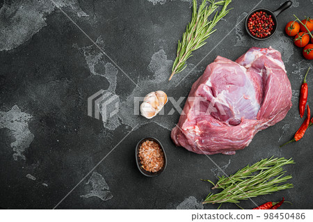 Raw pork meat with herbs, on black dark stone table background, top view flat lay, with copy space for text Raw pork meat with herbs, on black dark stone table background, top view flat lay, with copy space for text 98450486