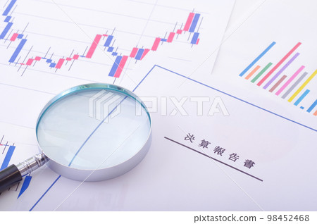 Earnings report, stock chart and magnifying glass 98452468