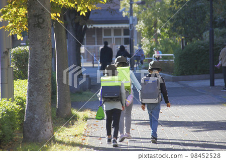 Back view of elementary school students going home from school, repeating while talking and playing Back view of elementary school students going home from school, repeating while talking and playing 98452528