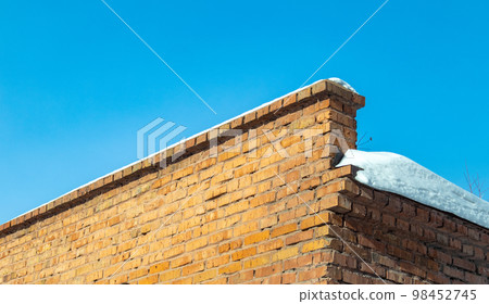 Brick brown old wall covered with snow 98452745