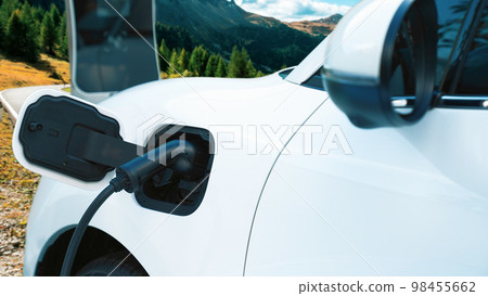 Progressive travel concept by EV car in remote mountain with charging station. 98455662