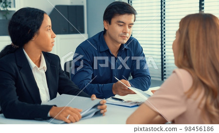 Young female asian candidate tries to impress interviewer by being competent. Young female asian candidate tries to impress interviewer by being competent. 98456186