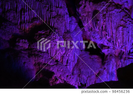 Illuminated stalactites in a limestone cave in Halong Bay, Vietnam 98456236