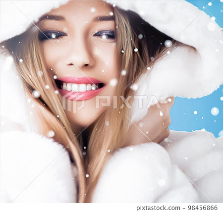 Happy holidays, beauty and winter fashion, beautiful woman wearing white fluffy fur coat, snowing snow on blue background as Christmas, New Year and holiday lifestyle portrait style 98456866