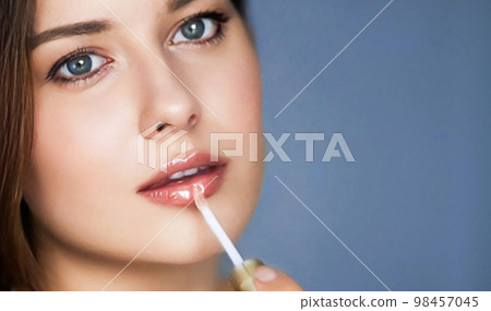 Beauty, makeup and skincare cosmetics model face portrait, beautiful woman applying lip gloss, cosmetic product and glamour make-up closeup Beauty, makeup and skincare cosmetics model face portrait, beautiful woman applying lip gloss, cosmetic product and glamour make-up closeup 98457045