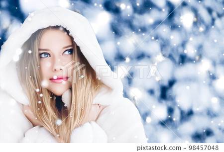 Happy holidays, lifestyle and winter fashion, beautiful woman wearing white fluffy fur coat, snowing snow in snowy forest nature as Christmas, New Year and holiday portrait style 98457048