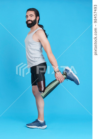 Man with a leg prosthesis stretching his upper quadriceps Man with a leg prosthesis stretching his upper quadriceps 98457493