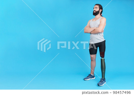 Man crossing arms standing with a leg prosthesis Man crossing arms standing with a leg prosthesis 98457496