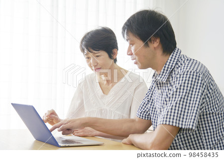 Mature couple using a computer at home Mature couple using a computer at home 98458435
