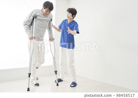 A man with a broken bone walking with crutches 98458517