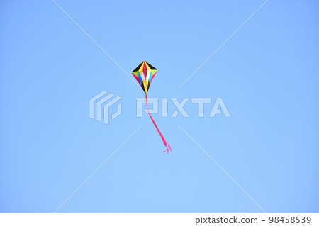 A kite flying high in the clear sky A kite flying high in the clear sky 98458539