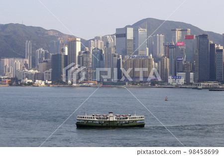 Star ferry in front of high-rise buildings in Hong Kong 98458699