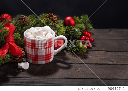Red mug with hot chocolate on top of which pieces of marshmallows float, with copy space Red mug with hot chocolate on top of which pieces of marshmallows float, with copy space 98459741