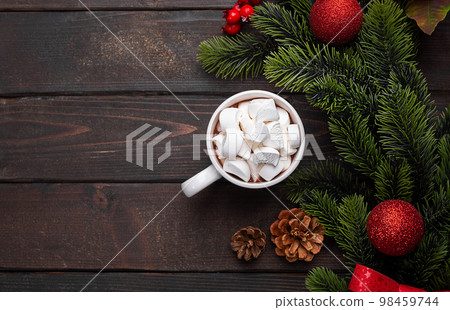 Red mug with hot chocolate on top of which pieces of marshmallows float, top view copy space 98459744