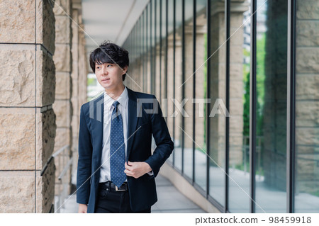 Businessman refreshingly walking in the office 98459918