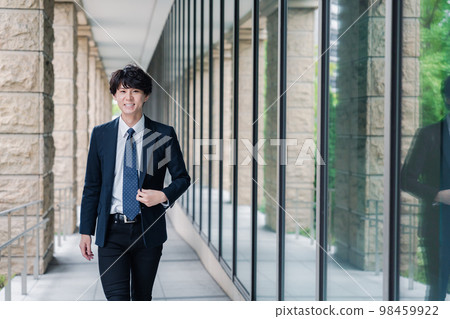Businessman refreshingly walking in the office Businessman refreshingly walking in the office 98459922