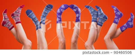 legs in christmas socks on orange background legs in christmas socks on orange background 98460506
