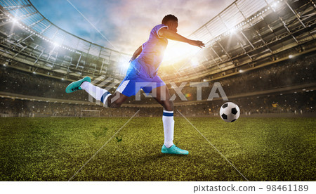 Close up of a football action scene with soccer player chases a soccerball at the stadium 98461189