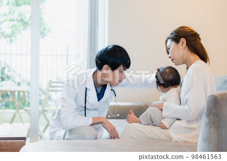 A baby being examined by a doctor who visited the house A baby being examined by a doctor who visited the house 98461563