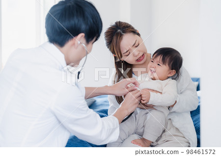 拜訪過這所房子的醫生正在檢查嬰兒 98461572