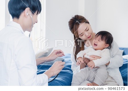 拜訪過這所房子的醫生正在檢查嬰兒 98461573
