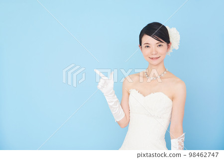 A woman in a wedding dress pointing with her finger A woman in a wedding dress pointing with her finger 98462747