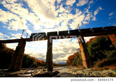 Arakawa Bridge in autumn leaves... An electric locomotive that is very active in towing freight cars 98464374