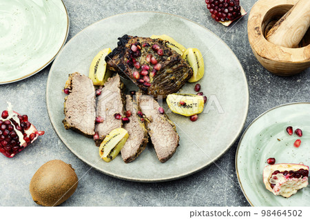 Beef meat baked with kiwi and pomegranate. Beef meat baked with kiwi and pomegranate. 98464502