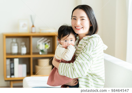 Young mother and child relaxing in the living room Young mother and child relaxing in the living room 98464547