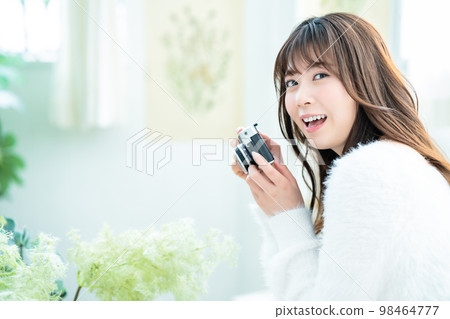 Camera girl shooting houseplants in the room Camera girl shooting houseplants in the room 98464777