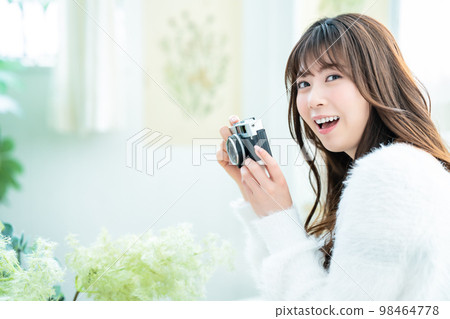 Camera girl shooting houseplants in the room Camera girl shooting houseplants in the room 98464778