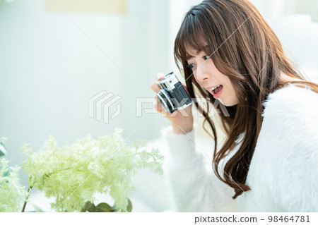 Camera girl shooting houseplants in the room Camera girl shooting houseplants in the room 98464781