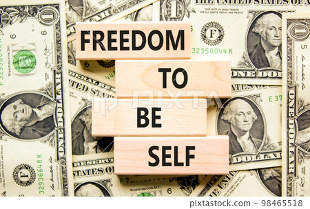 Freedom to be self symbol. Concept words Freedom to be self on wooden blocks on a beautiful background from dollar bills. Business, psychological freedom to be self concept. 98465518