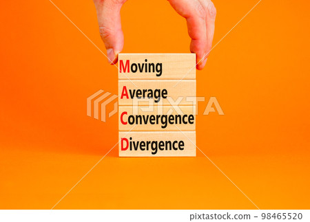 MACD symbol. Concept words MACD moving average convergence divergence on wooden block on beautiful orange background. Business MACD moving average convergence divergence concept. Copy space. 98465520