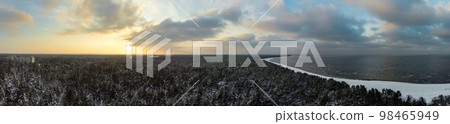 Sunrise over a calm bird's eye view of the sea and forest. Dramatic sunset on the Baltic sea in winter. Sunrise over a calm bird's eye view of the sea and forest. Dramatic sunset on the Baltic sea in winter. 98465949
