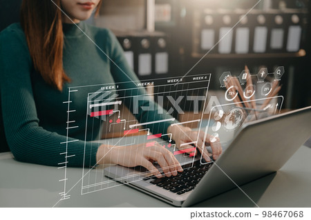 woman hand Project manager working and update tasks and Gantt chart scheduling virtual diagram with laptop in office. 98467068