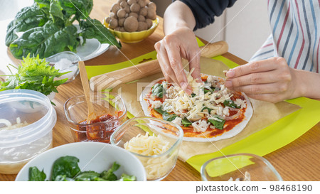 Image of a woman making pizza 98468190