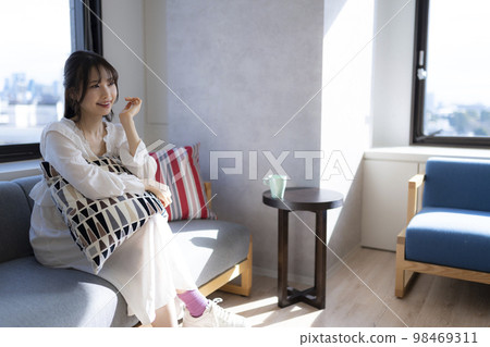 一個女人在辦公室的沙發上放鬆時交談。 98469311