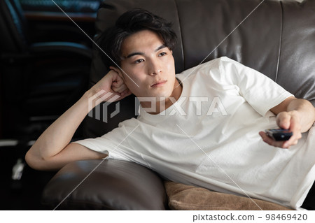 男人心不在焉地看電視 98469420