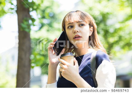 年輕女子在智能手機上交談 98469743