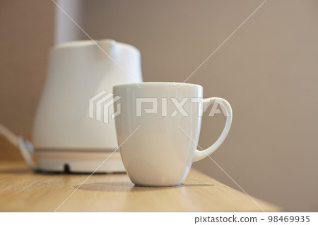 State of electric kettle and cup in hotel room 98469935