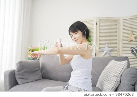 Woman doing arm self hair removal at home 98470268