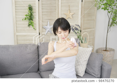 Woman doing arm self hair removal at home Woman doing arm self hair removal at home 98470270