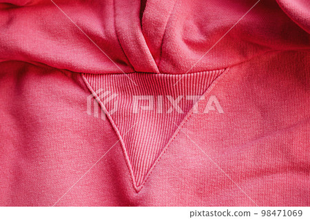 Macro detail of pink knitted hoodie. Fabric as a background. Macro detail of pink knitted hoodie. Fabric as a background. 98471069