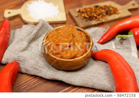 Ajvar from sweet peppers, eggplant, tomatoes, garlic and onions with spices wooden table. Balkan food. Selective focus Ajvar from sweet peppers, eggplant, tomatoes, garlic and onions with spices wooden table. Balkan food. Selective focus 98472158