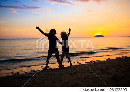 Child playing on ocean beach. Kid at sunset sea. Child playing on ocean beach. Kid at sunset sea. 98472205